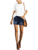 Full front view of model wearing blue mid-waist raw hem distressed faded denim shorts