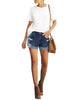 Full front view of model wearing blue mid-waist rolled hem distressed denim shorts