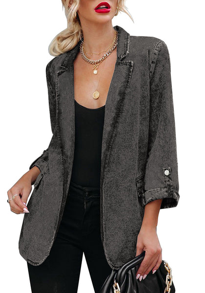 Model poses wearing grey lapel collar flap pockets open-front denim blazer