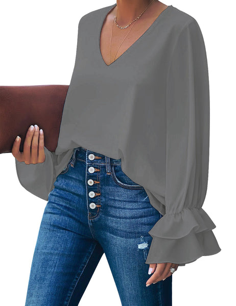 Angled shot of model wearing grey ruffle cuff long sleeves V-neck blouse