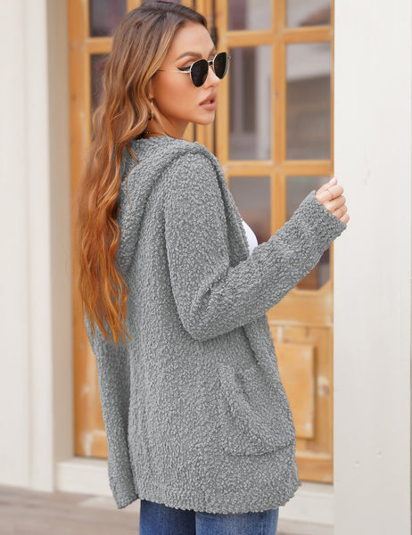 Side view of model wearing light grey button down melange waffle knit hooded cardigan