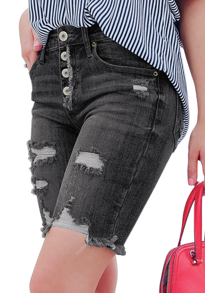 Angled shot of model wearing black frayed hem ripped button-up denim bermuda shorts