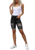 Front full body shot of model wearing black plus size mid-waist ripped denim bermuda shorts.