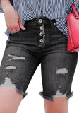 Model wearing black frayed hem ripped button-up denim bermuda shorts