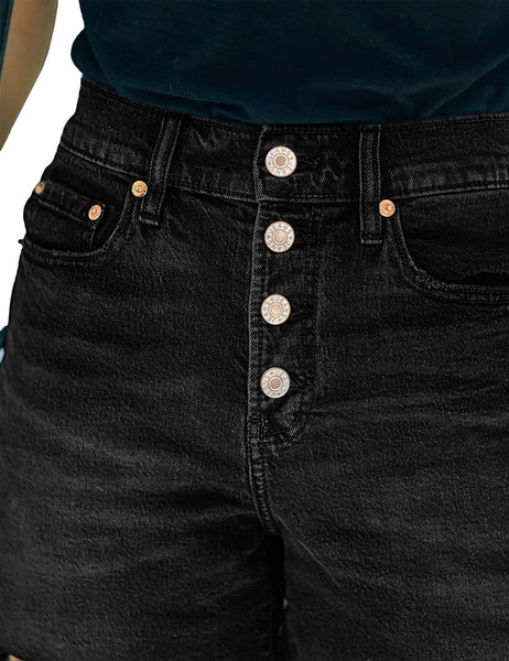 Closeup view of black raw hem mid-waist distressed denim shorts