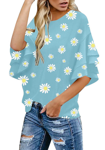 Angled shot of model wearing light blue trumpet sleeves keyhole-back daisy printed blouse