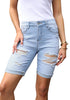 Model poses wearing light blue plus size mid-waist ripped denim bermuda shorts.