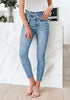 Front view of model wearing light blue high-waist acid wash belted denim skinny jeans