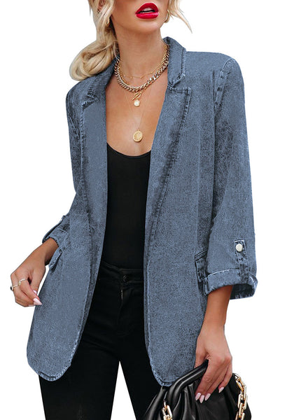 Model poses wearing blue lapel collar flap pockets open-front denim blazer