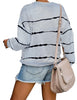 Back view of model wearing grey striped drop shoulder pullover sweater