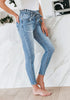 Model poses wearing light blue high-waist acid wash belted denim skinny jeans