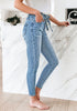 Side view of model wearing light blue high-waist acid wash belted denim skinny jeans