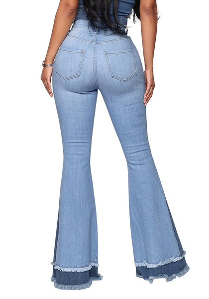 Back view of model wearing medium blue stretchy frayed hem flared denim jeans