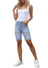 Front full body shot of model wearing light blue plus size mid-waist ripped denim bermuda shorts.