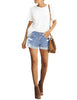 Ful front view of model wearing light blue mid-waist rolled hem distressed denim shorts