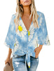 Front view of model wearing light blue tie-dye daisy V-neckline button-up tie-front top