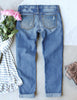 Back view of blue flower-print patch ripped rolled hem denim boyfriend jeans