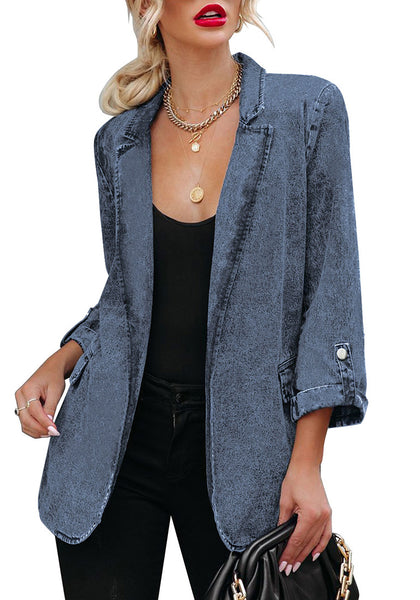 Model poses wearing deep blue lapel collar flap pockets open-front denim blazer