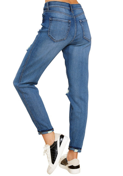 Back view of model wearing women's dark blue distressed button-up boyfriend jeans