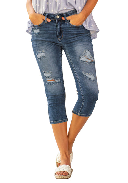Model poses wearing blue below knee cropped skinny denim jeans