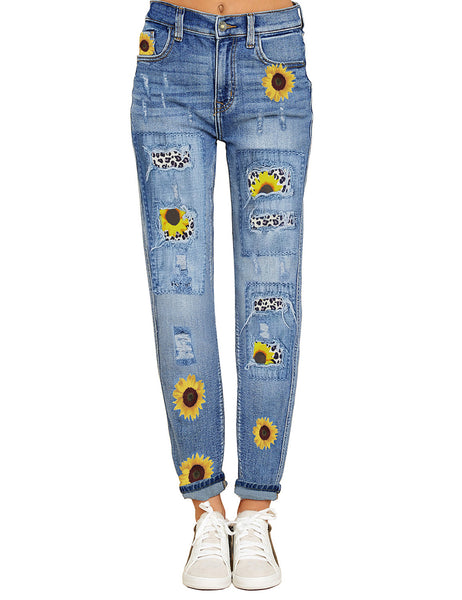 Front view of model wearing blue sunflower-print patch ripped rolled hem denim boyfriend jeans