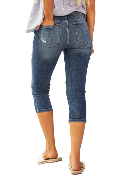 Back view of model wearing blue below knee cropped skinny denim jeans