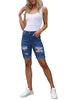 Front full body shot of model wearing blue plus size mid-waist ripped denim bermuda shorts.