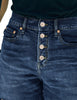 Closeup shot of dark blue raw hem mid-waist distressed denim shorts