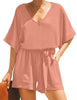 Front view of model wearing blush V-neckline keyhole-back loose belted romper