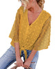 Model poses wearing mustard yellow 3/4 sleeves pompom tie-front top