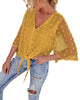 Angled view of model wearing mustard yellow 3/4 sleeves pompom tie-front top