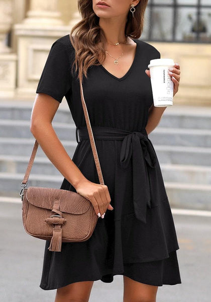 Angled shot of model wearing black V-neckline short sleeves belted ruffle dress