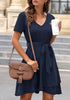 Angled shot of model wearing navy V-neckline short sleeves belted ruffle dress