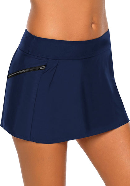 Angled shot of model wearing navy zipper-pocket waistband skirted bikini bottom