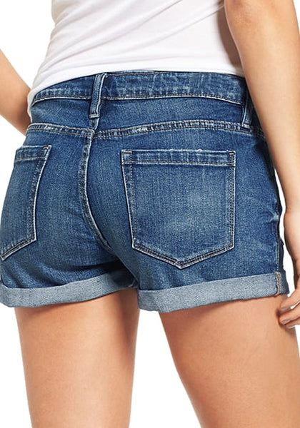Back view of model in blue roll-over hem button-up distressed denim shorts
