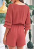 Back view of model wearing coral pink 34 bell mesh panel sleeves belted romper
