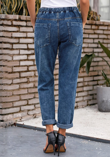 Back view of model wearing dark blue drawstring-waist cuffed ripped boyfriend jeans