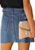 Back view of model wearing dark blue raw hem distressed denim mini skirt