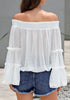 Back view of model wearing white bell sleeves dotted loose off-shoulder top