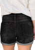 Back view of model wearing black roll-over hem button-up ripped denim shorts