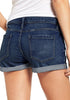 Back view of model wearing dark blue roll-over hem button-up distressed denim shorts