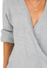 Closeup shot of woman wearing light grey lantern sleeves surplice sweater