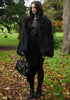 Edgy all black style of model in black faux fur coat