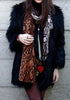 Front view of model in black faux fur with scarf