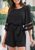 Front view of model wearing black 34 bell mesh panel sleeves belted romper