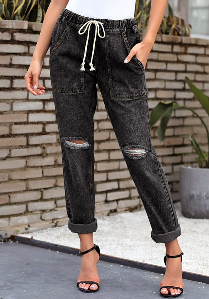 Front view of model wearing black drawstring-waist cuffed ripped boyfriend jeans