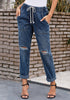 Front view of model wearing dark blue drawstring-waist cuffed ripped boyfriend jeans