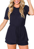 Front view of model wearing navy crew neck overlay drawstring knit romper
