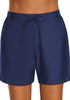 Front view of model wearing navy lace-up board shorts