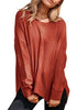 Front view of model wearing rust red ribbed knit textured side-slit sweater